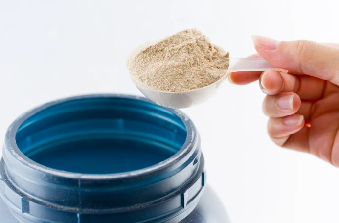 プロテインをスプーンですくっているところ